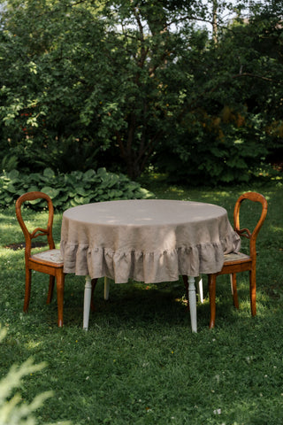 Apaļš lina galdauts kapučīno krāsā ar volāniem uz galda
Round linen tablecloth in cappuccino color with ruffles on a table
