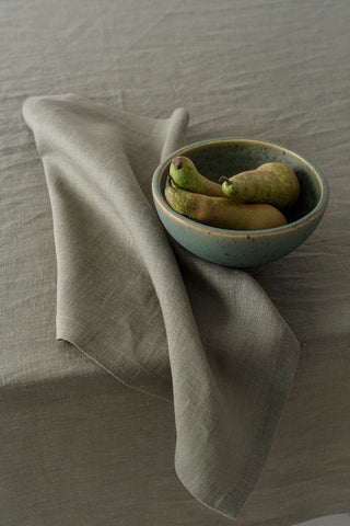 olīvzaļa salvete ar galdautu un bumbieriem