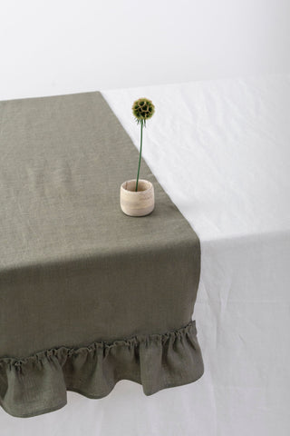 Olīvzaļš lina galda celiņš ar volāniem ar vāzi