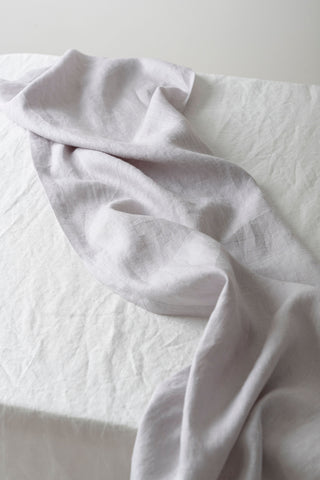 gaiši pelēks lina celiņš uz galda