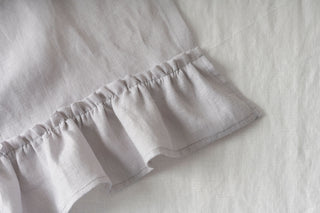 gaiši pelēks lina celiņš ar volānu tuvplānā