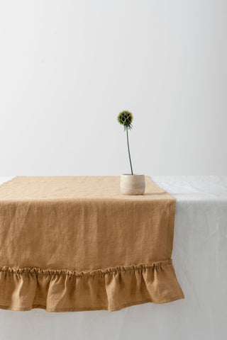 karameļu lina celiņš ar volāniem uz galda