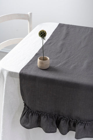 pelēks lina celiņš ar volānu un vāzi