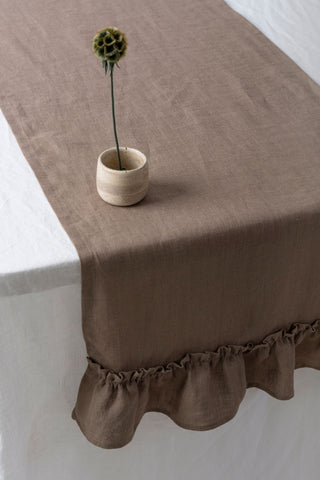 Brūns lina galda celiņš ar volāniem ar vāzi