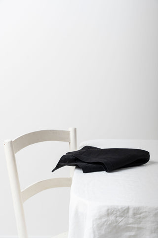 Melna lina salvete uz galda malas